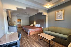 een hotelkamer met een bed en een bank bij Regency Inn & Suites By Capital O Houston IAH Airport in Humble +62 foto's