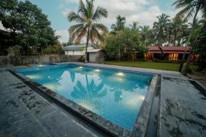a swimming pool in front of a house at Kashid Heritage Beach Resort in Kashid