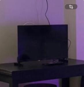 een flatscreen-tv zittend op een tafel bij Studio cosy et calme à Garches in Garches