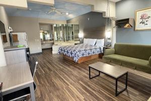 een hotelkamer met een bed en een bank bij Regency Inn & Suites By Capital O Houston IAH Airport in Humble