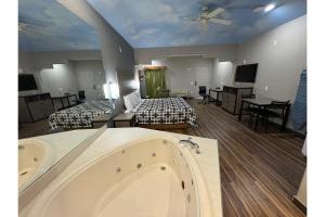 een grote kamer met 2 bedden en een bad bij Regency Inn & Suites By Capital O Houston IAH Airport in Humble
