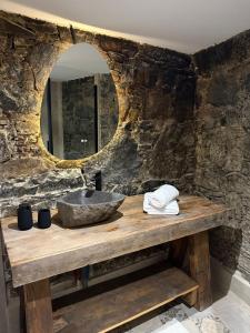 a stone bathroom with a sink and a mirror at Aprosmeno House 6 in Agros