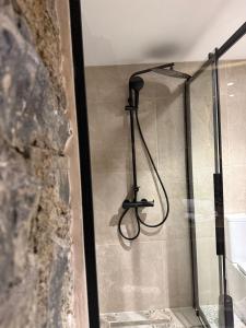 a shower with a hose hanging from a wall at Aprosmeno House 6 in Agros