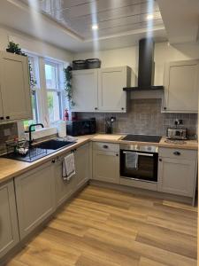 a kitchen with white cabinets and a stove top oven at Arthur's View in Dalkeith