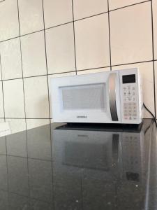 a microwave sitting on top of a table at 1 Quarto passos da praia in Fortaleza