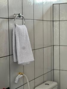 a bathroom with a white towel hanging on a wall at 1 Quarto passos da praia in Fortaleza +25 photos