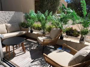 a patio with chairs and a table and plants at Lou soulèu in Cassis