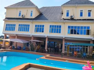 a large building with a swimming pool in front of it at 6A Resort in Owerri
