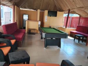 a billiard room with a pool table and chairs at 6A Resort in Owerri