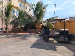 a building with palm trees in a parking lot at 6A Resort in Owerri