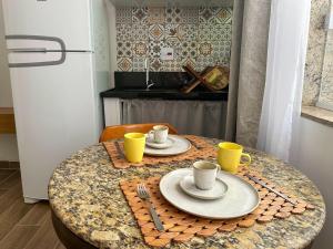 a table with two cups and saucers on it at Vila em Laranjeiras in Rio de Janeiro +8 photos