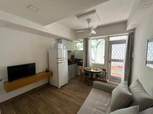a living room with a refrigerator and a table at Vila em Laranjeiras in Rio de Janeiro