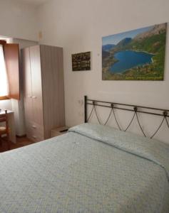 een slaapkamer met een bed en een schilderij aan de muur bij La Casa di Rossella - pernottamento senza colazione in Scanno +11 foto's