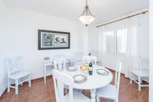 una sala da pranzo bianca con tavolo e sedie bianchi di Villa Nispero a El Tosalet