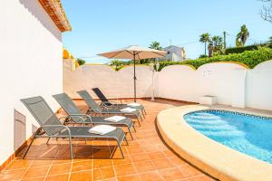 un gruppo di sedie sedute accanto a una piscina di Villa Nispero a El Tosalet