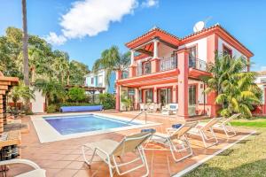 a house with a swimming pool and chairs at Villa Oceana in Manilva