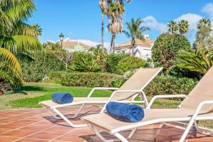 a pair of lounge chairs on a patio at Villa Oceana in Manilva