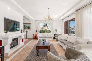 a living room with white furniture and a fireplace at Villa Oceana in Manilva