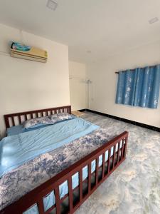 une chambre avec un grand lit avec des draps bleus dans l'établissement Garden Hostel Koh Rong, à Sihanoukville