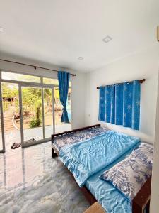 une chambre avec un lit et une grande fenêtre dans l'établissement Garden Hostel Koh Rong, à Sihanoukville