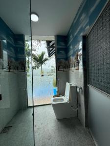 a bathroom with a toilet with a view of the ocean at Bliss Lodge Diyaluma in Demodara +26 photos