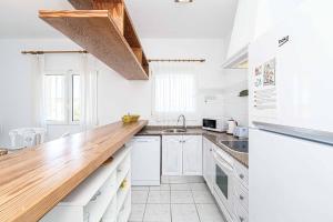 una cucina con mobili bianchi e un piano di lavoro in legno di Villa Pera a El Tosalet