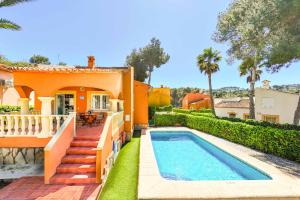 una casa arancione con piscina e cortile di Villa Pinya a El Tosalet