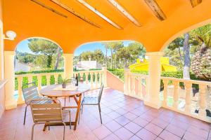 un patio con tavolo e sedie su un balcone di Villa Pinya a El Tosalet