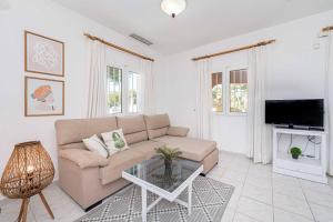 un soggiorno con un divano e una TV di Villa Pinya a El Tosalet