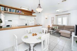 una cucina e un soggiorno con tavolo e sedie bianchi di Villa Pinya a El Tosalet