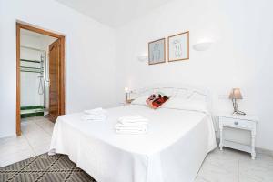 una camera da letto bianca con un letto e asciugamani di Villa Pinya a El Tosalet Altre 19 foto