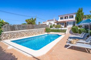 a swimming pool in front of a house at Villa Punta Rosa in Punta Prima