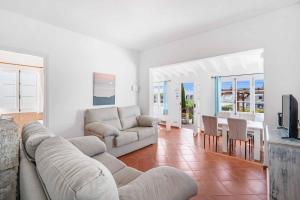 a living room with a couch and a table at Villa Punta Rosa in Punta Prima