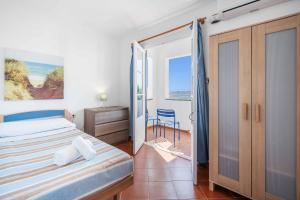 a bedroom with a bed and a view of the ocean at Villa Punta Rosa in Punta Prima +16 photos