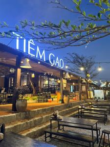 a restaurant with benches in front of it at night at GAJOs HOUSE in Thanh Xuân