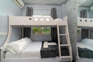 ein Schlafzimmer mit zwei Etagenbetten und einem Spiegel in der Unterkunft Naseema Hiya - Central Ukulhas Residences in Ukulhas