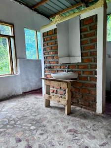 La salle de bains est pourvue d'un lavabo sur un mur en briques. dans l'établissement Migogo Gorilla Lodge, à Rubuguli 38 autres photos