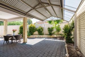 a pergola with a table and chairs on a patio at Queens Residence Perth Western Australia in Perth