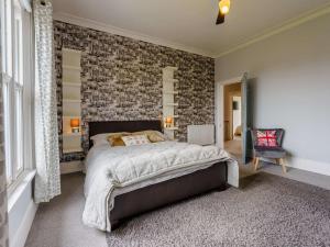 a bedroom with a large bed with a brick wall at 5 Bed in Sandown oc-87008 in Sandown