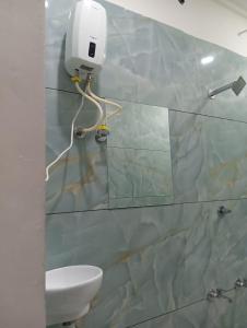 een badkamer met een toilet en een muur met tegels bij hotel suncity in Pālanpur