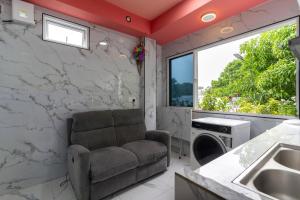 ein Wohnzimmer mit einem Stuhl und einem Fenster in der Unterkunft Naseema Hiya - Central Ukulhas Residences in Ukulhas + 56 Fotos