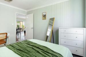 a bedroom with a bed and a dresser and a mirror at Queens Residence Perth Western Australia in Perth