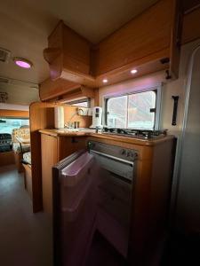 een kleine keuken met een fornuis en een spoelbak bij Camper room bunde in Bunde