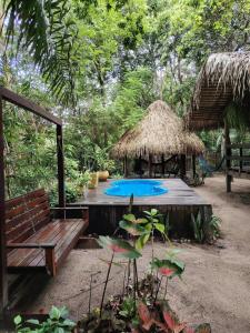 a swimming pool with a hut and a bench at Recanto Shanti in Alter do Chao