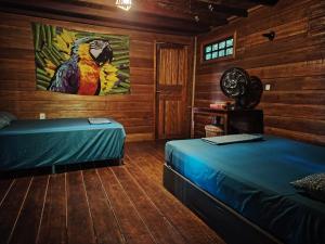 a bedroom with two beds and a painting of a parrot at Recanto Shanti in Alter do Chao +32 photos