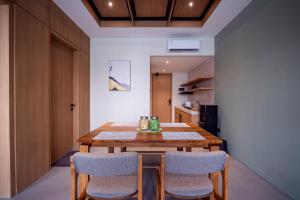 une salle à manger avec une table et des chaises en bois dans l'établissement Amani Suites Yogyakarta, à Timuran 41 autres photos
