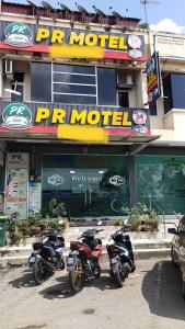 a row of motorcycles parked in front of a store at Capital O 91275 Pr Motel in Changlun