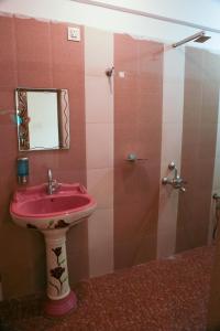 a bathroom with a pink sink and a shower at Dreamcatcher House & Hostel at Arambol Beach in Arambol