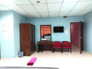 a room with two chairs and a desk and a tv at Capital O 91275 Pr Motel in Changlun