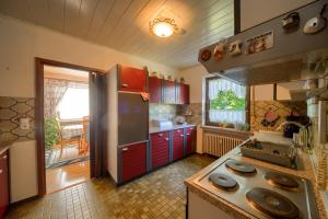 a kitchen with red cabinets and a stainless steel refrigerator at Ferienwohnung in Lichtenfels mit 125 Quadratmeter in Lichtenfels